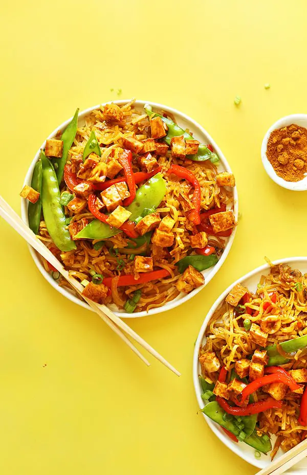 Dinner plates piled high with delicious Vegan Singapore Noodles for a flavorful simple meal