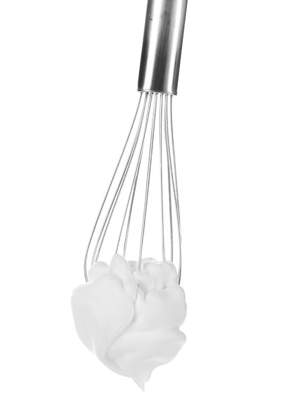 Metal whisk with whipped egg witsh shadows whites on white background